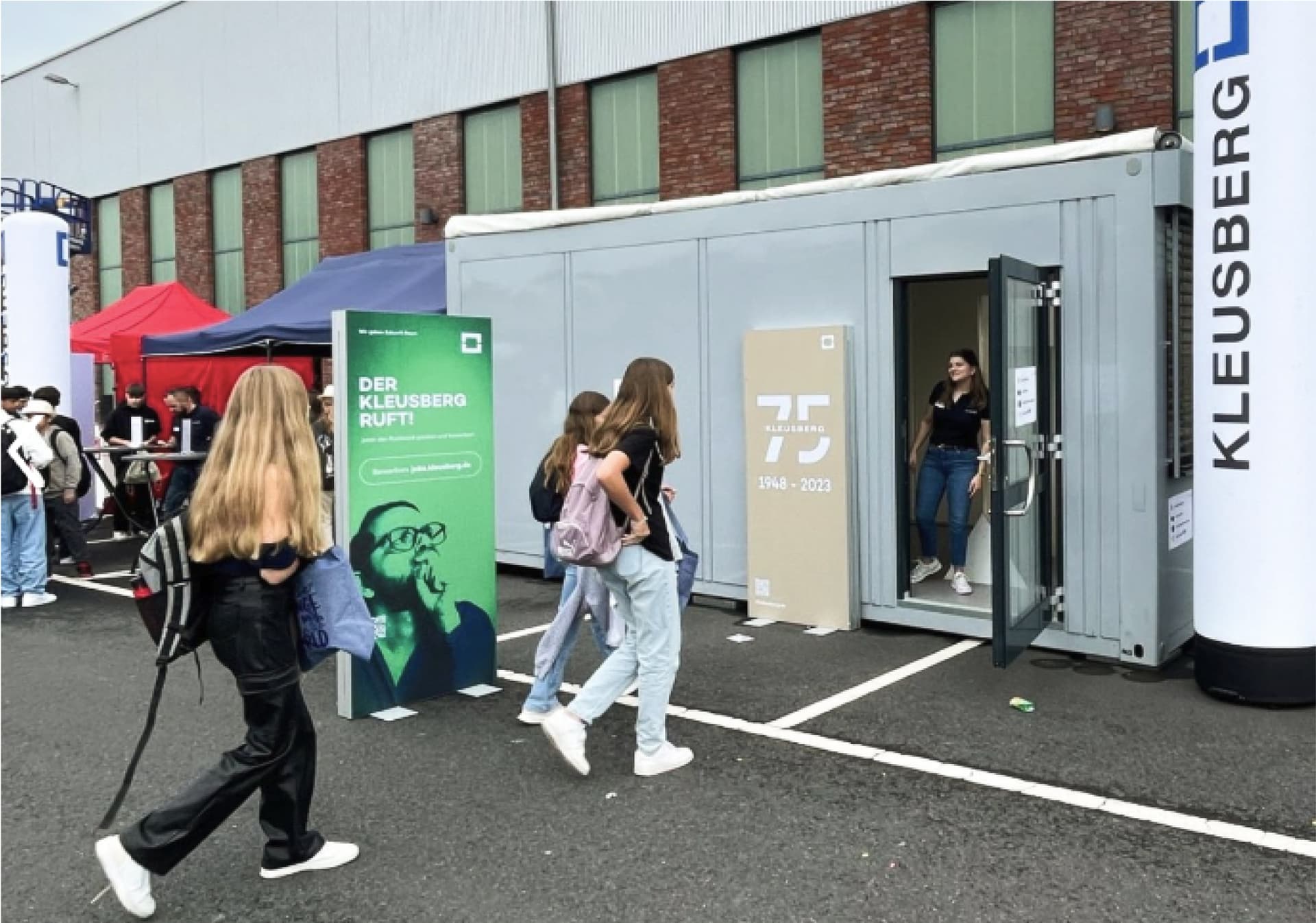 Kinder gehen in einen Container von Kleusberg rein. 