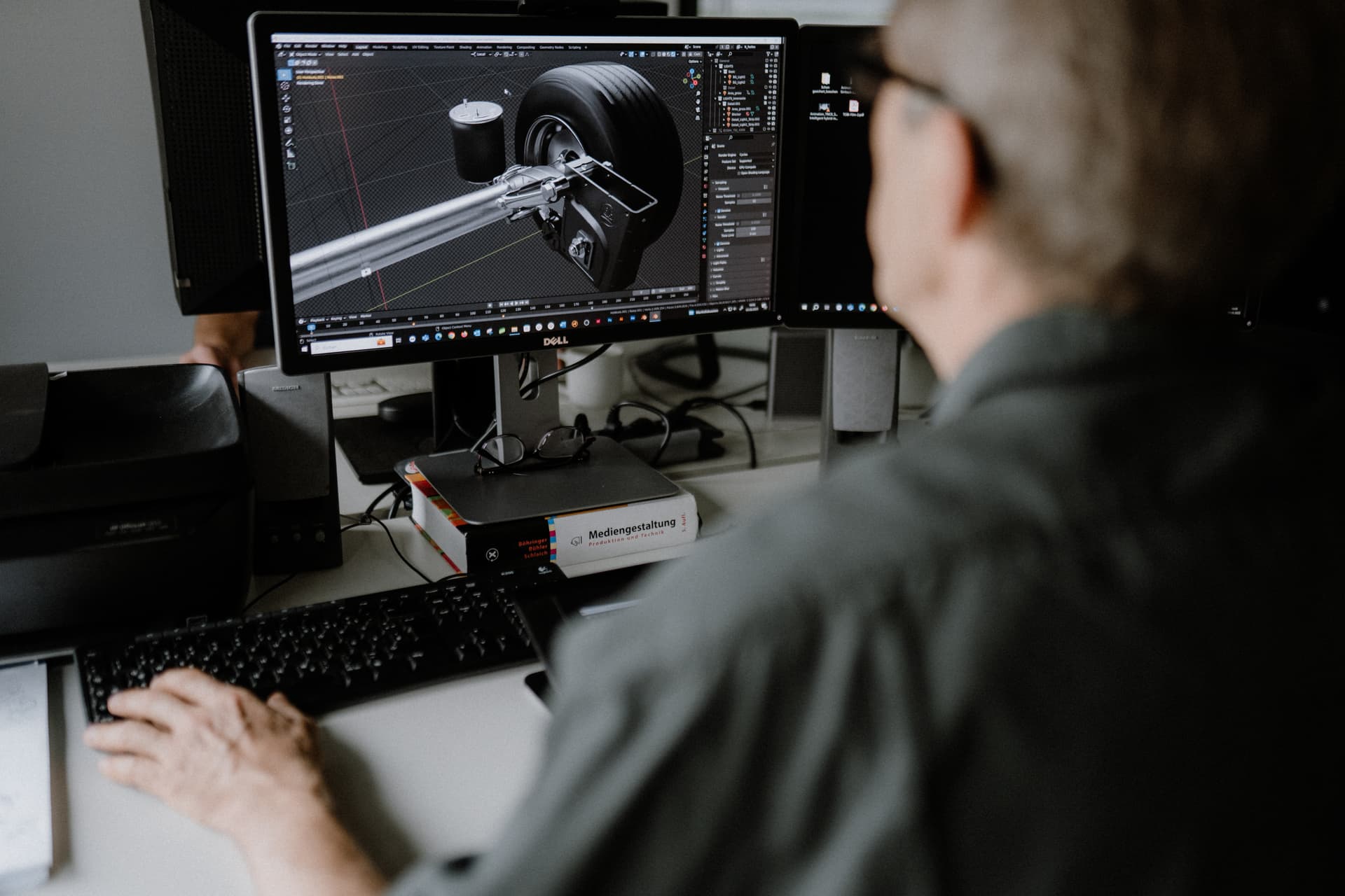 Mitarbeiter einer 3D-Agentur bei der 3D-Modellierung eines Fahrwerks am Computer.
