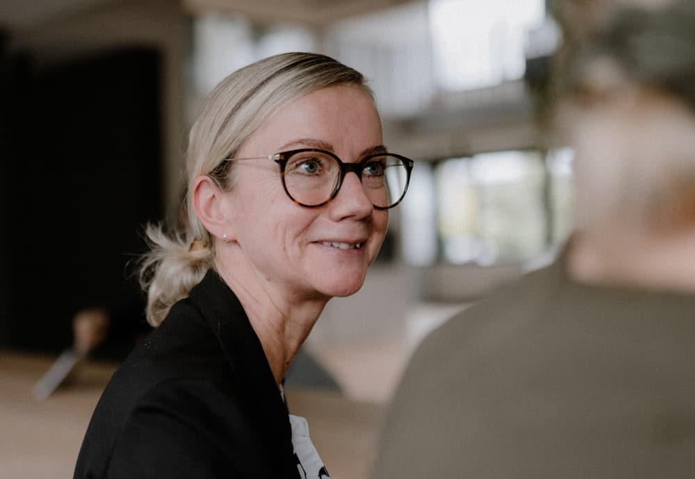 Eine Frau lacht ihre Kollegin an